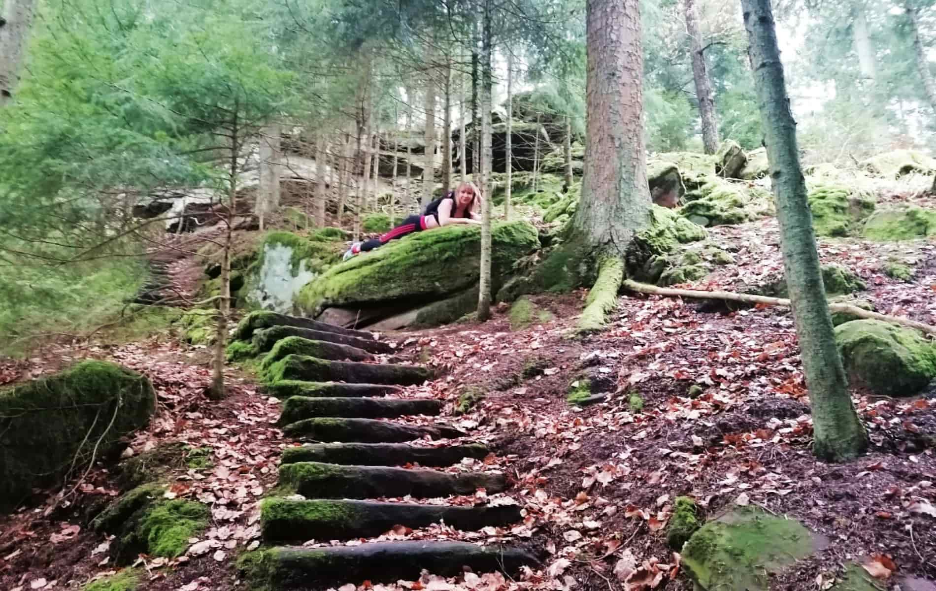 Frau liegt auf Waldboden