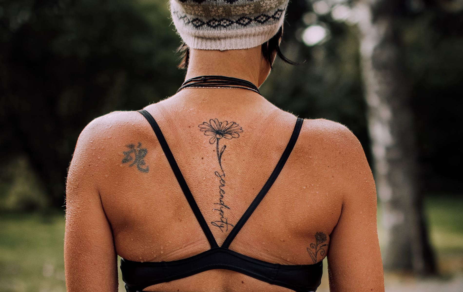 Rücken einer Frau im Bikini mit dezentem Tattoo