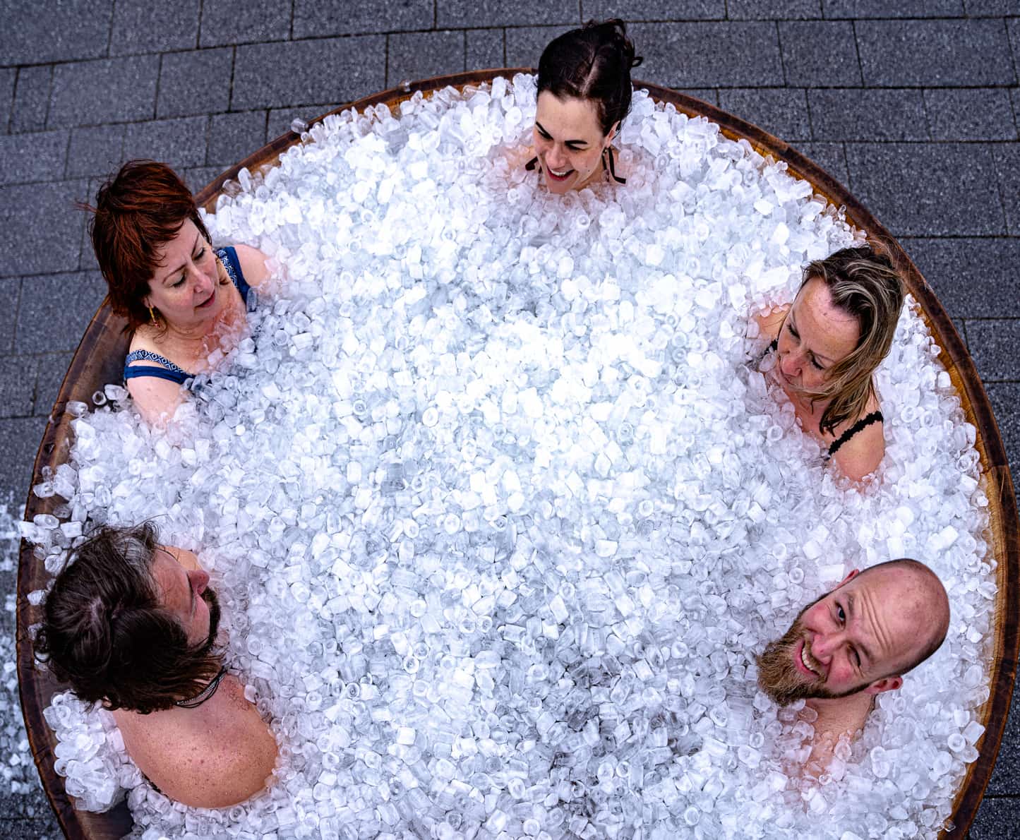 Fünf Menschen sitzen in gefülltem Eisbadezuber