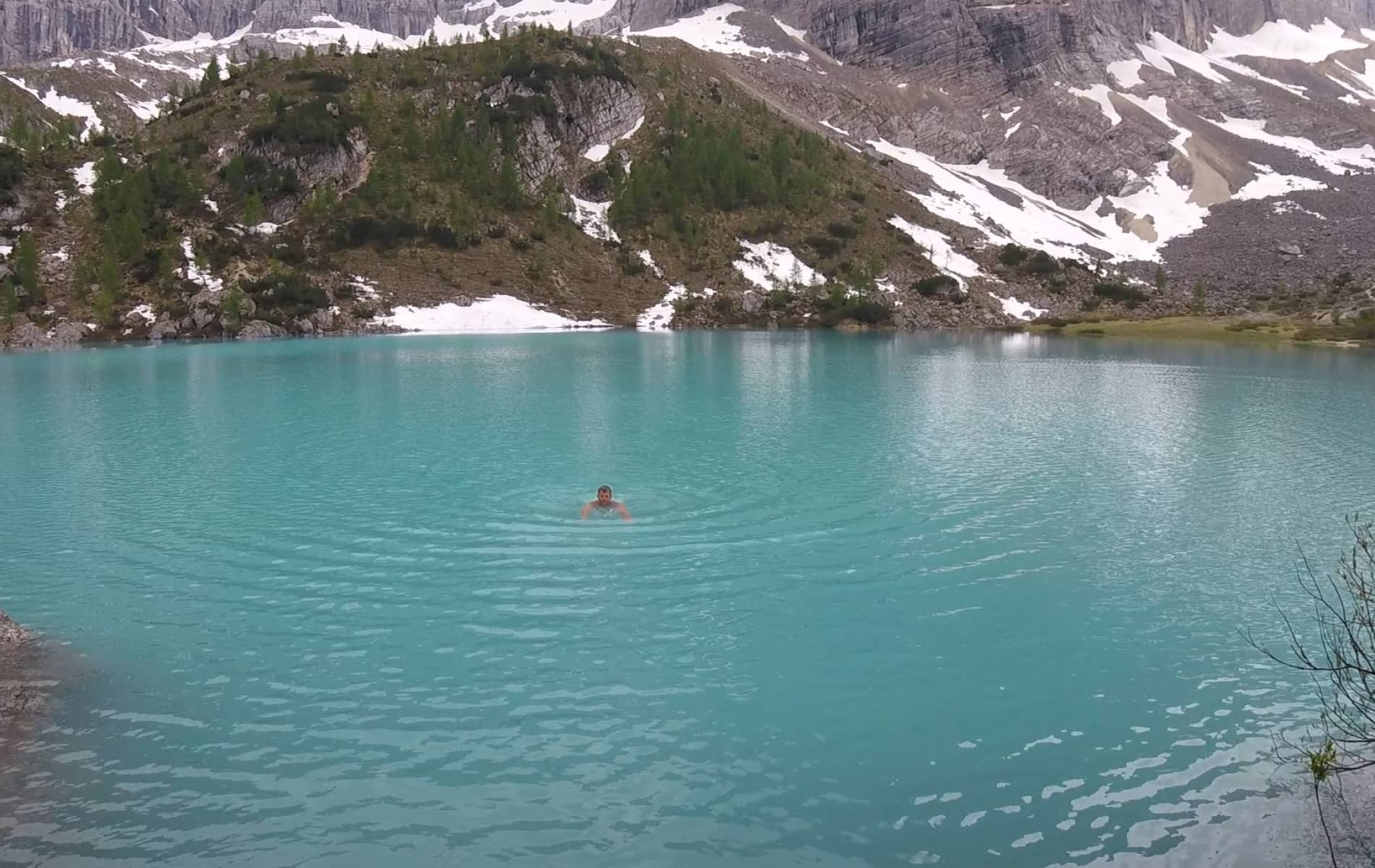 Mann schwimmt in Bergsee