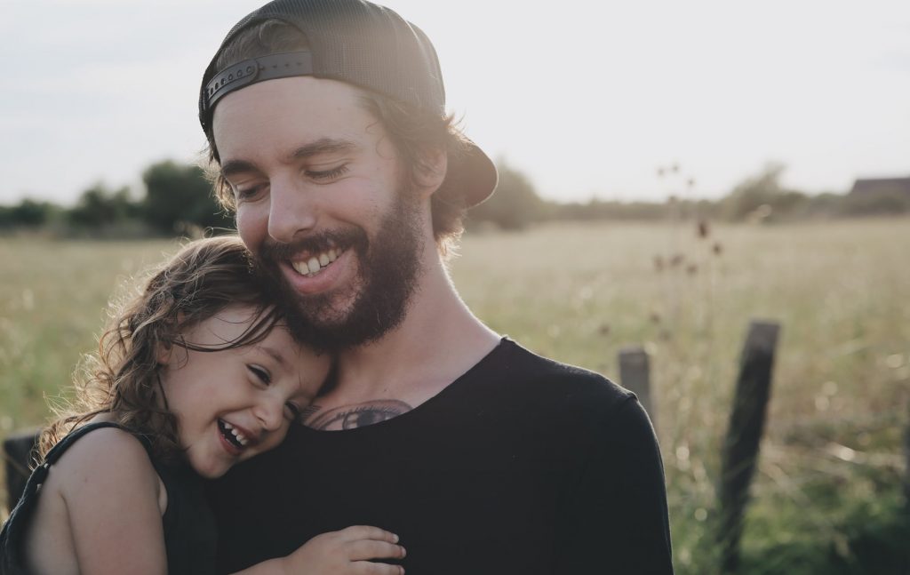 Mann hält Kind lachend im Arm | Biohacking BD