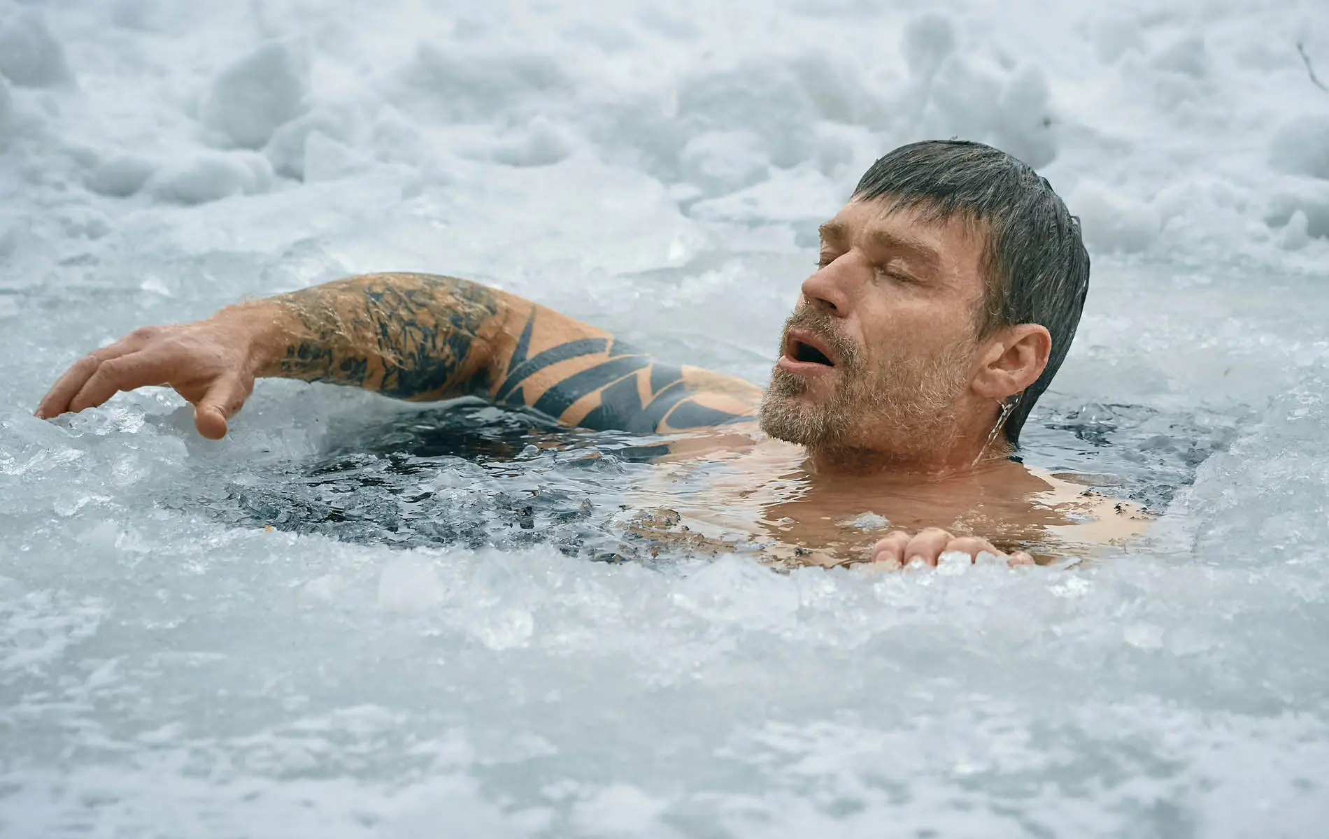 mann im eisbad und wendet zugleich die wim hof methode an.