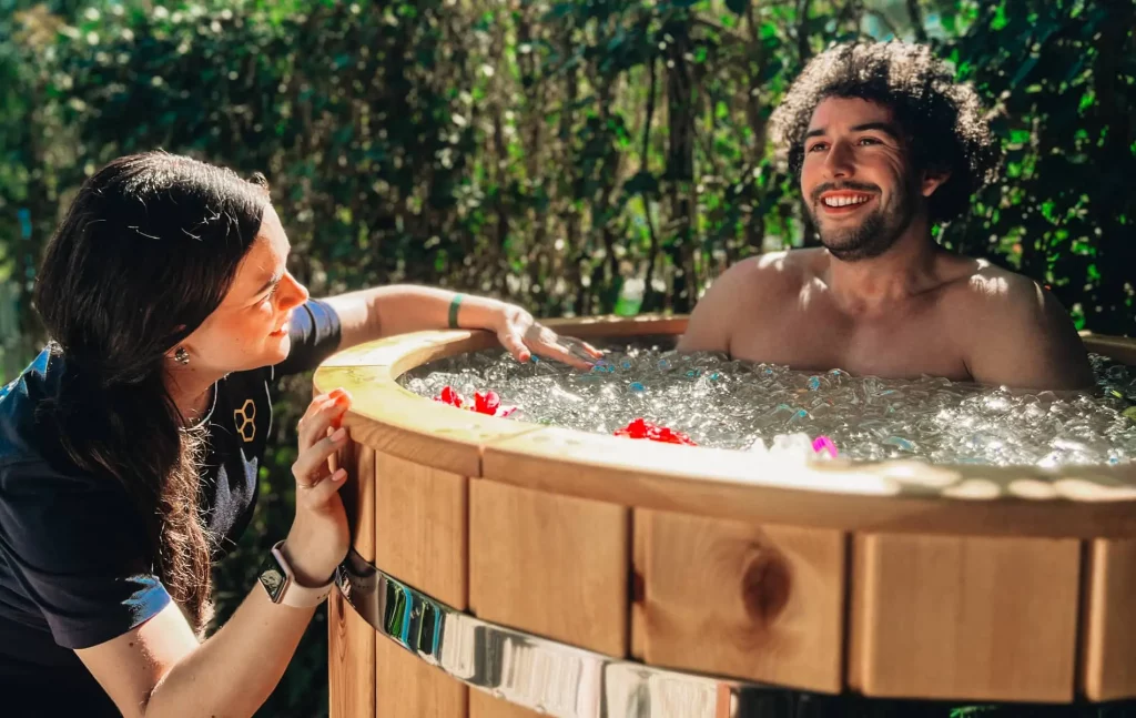 Mann im Eisbad mit einer Frau, die das Eisbad leitet