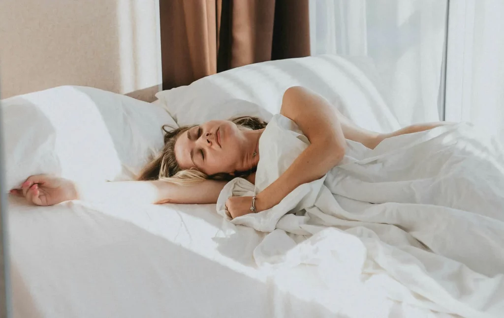 Frau, die dank Wim-Hof-Atmung entspannt im Bett schläft
