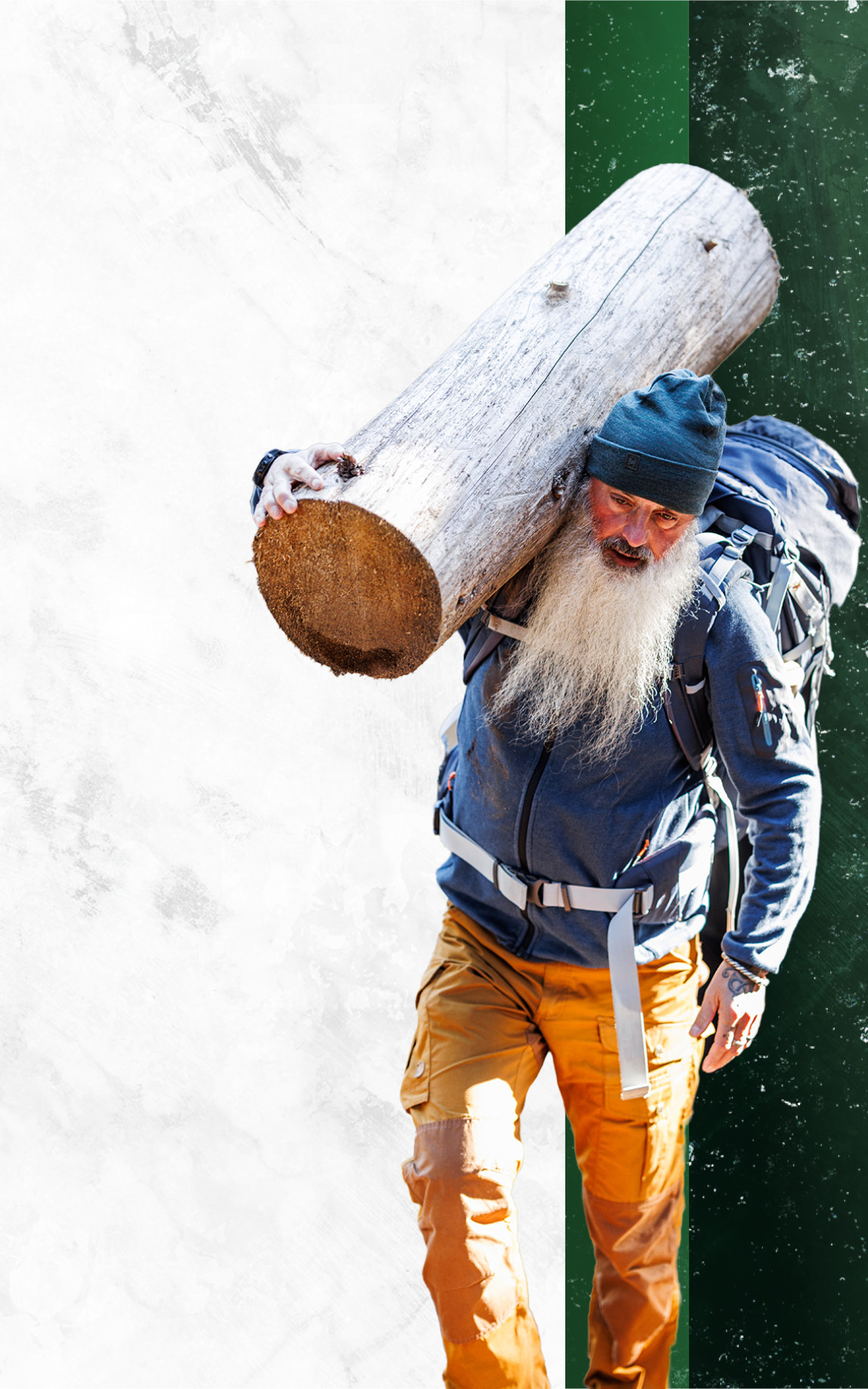 Ansagar Küchle ein Feuerlauftrainer, Wildnispädagoge und Gründer eines eigenen Outdoorzentrums im Westerwald. Zu sehen ist er, wie er einen großen Baumstamm auf der Schulter trägt. Er trägt zudem Outdoor-Kleidung.